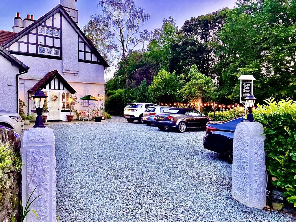 a driveway with cars parked in front of a house at Storrs Gate House in Bowness-on-Windermere