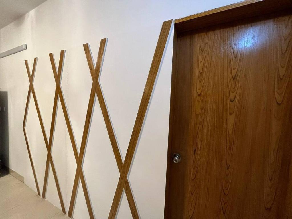 een houten deur in een kamer naast een muur bij Private Room near Istanbul Airport 5 in Arnavutköy