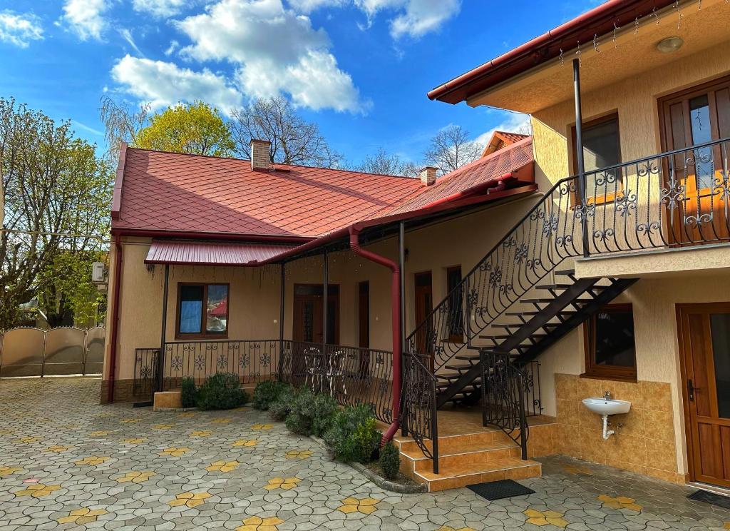 een huis met een balkon en een trap bij Villa Magda in Berehove