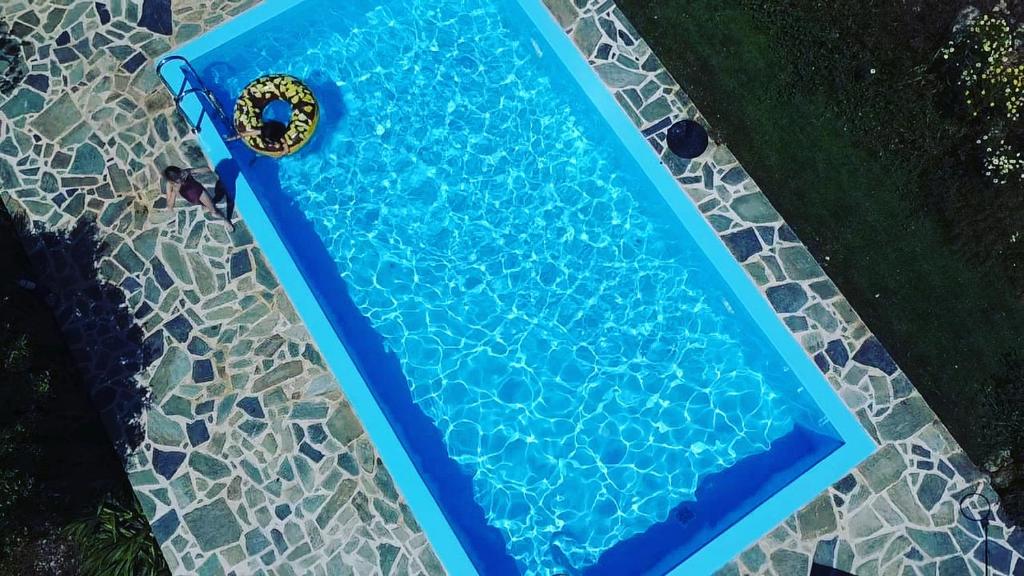 - une vue sur la piscine bleue et une chaise dans l'établissement Villa Edna Crete, à Agios Nikolaos