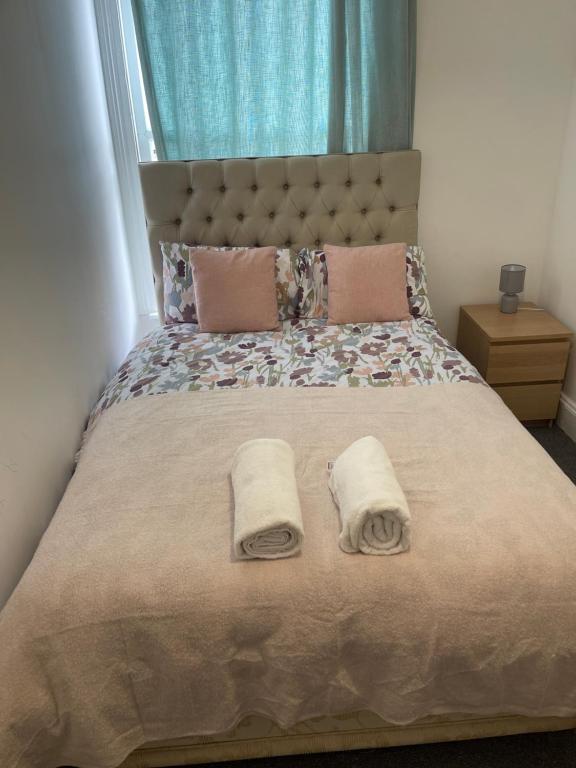 a bedroom with a bed with two towels on it at private room 6 in Bristol