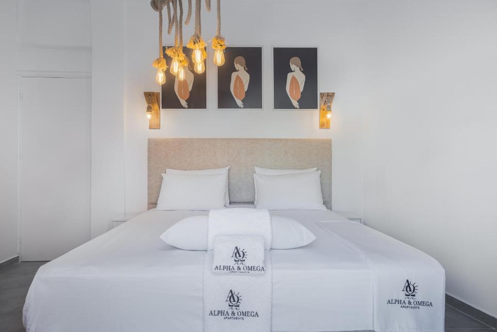 een slaapkamer met een wit bed en 2 witte kussens bij Alpha & Omega in Karpathos