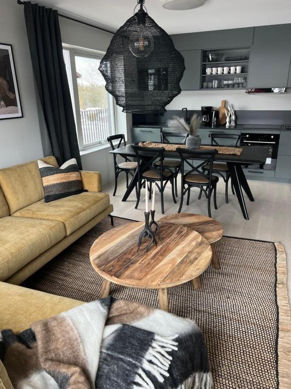 uma sala de estar com um sofá, uma mesa e cadeiras em Fjällglim36 em Sälen
