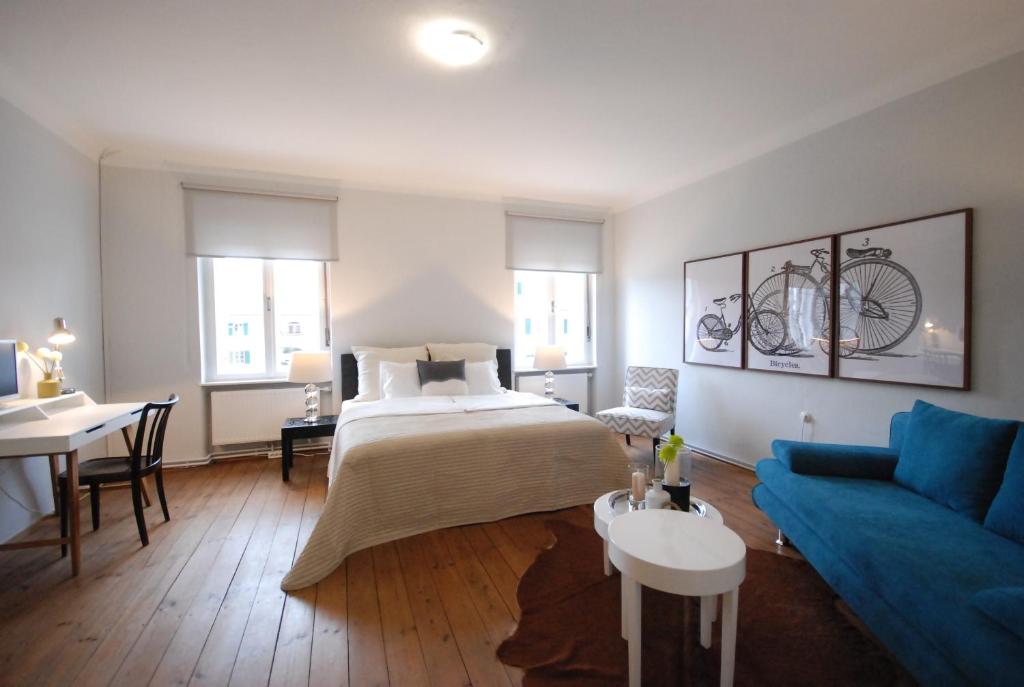 1 dormitorio con 1 cama y 1 sofá azul en Gästewohnung Ida, en Oberwart