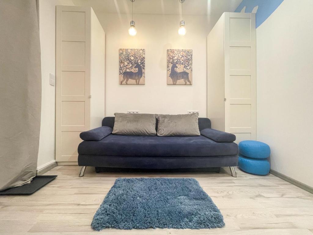ein Wohnzimmer mit einem blauen Sofa und einem blauen Teppich in der Unterkunft Solne Apartamenty Luna in Wieliczka