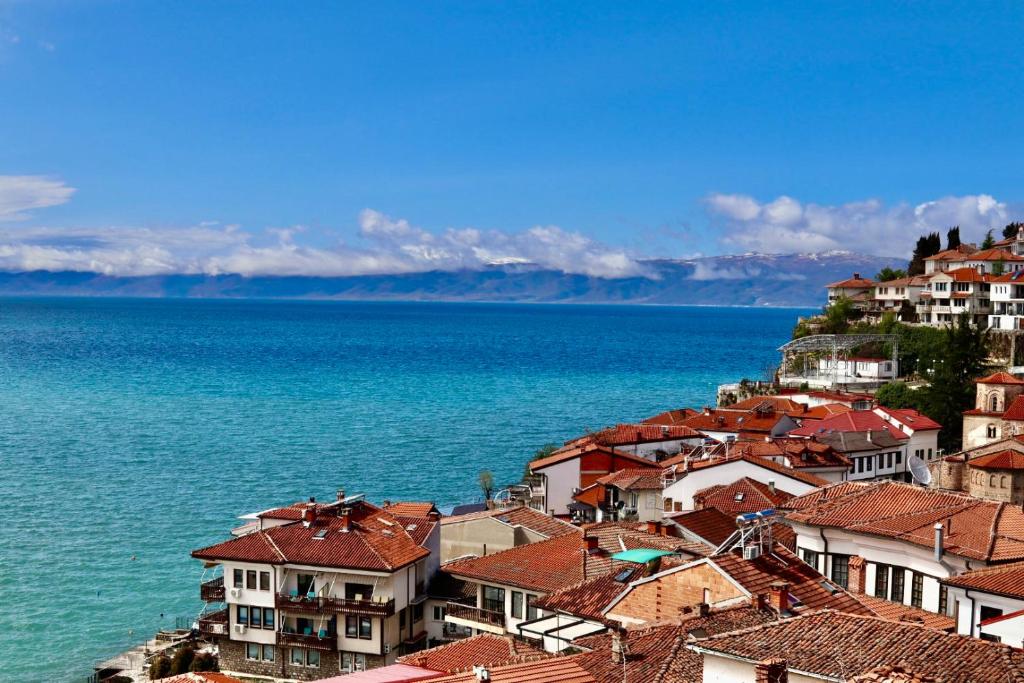 een groep huizen op een heuvel naast het water bij PS Apartments in Ohrid