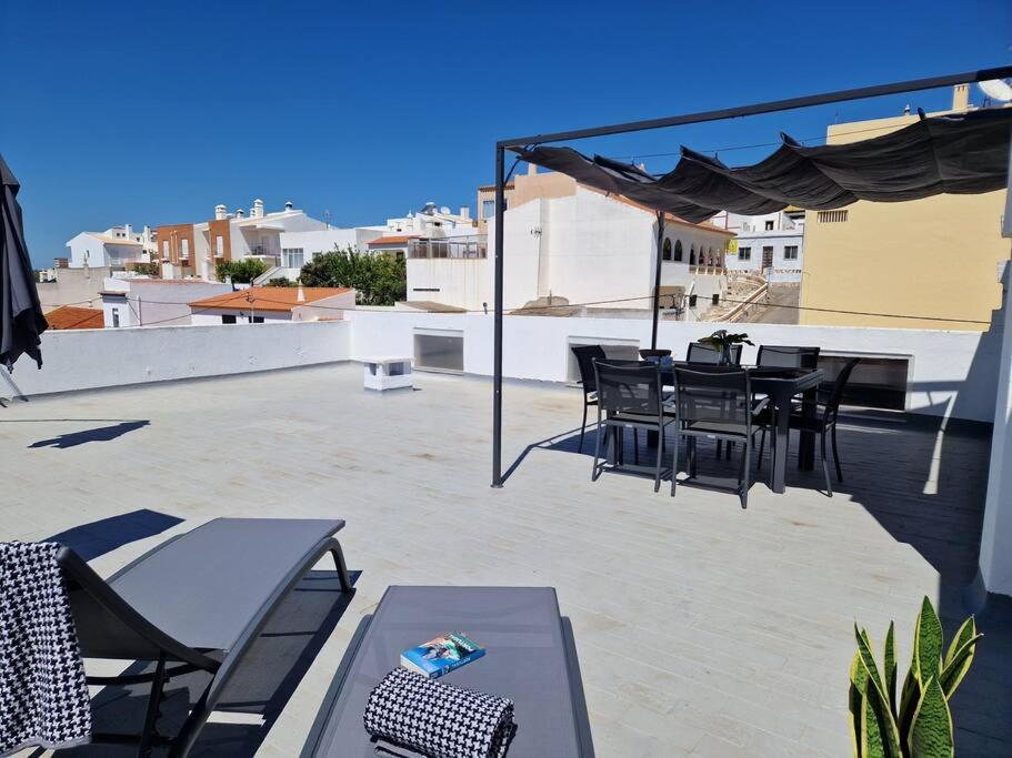 d'une terrasse sur le toit avec des tables et des chaises. dans l'établissement Casa Liberdade - Modern townhouse with terrace roof, à Estômbar