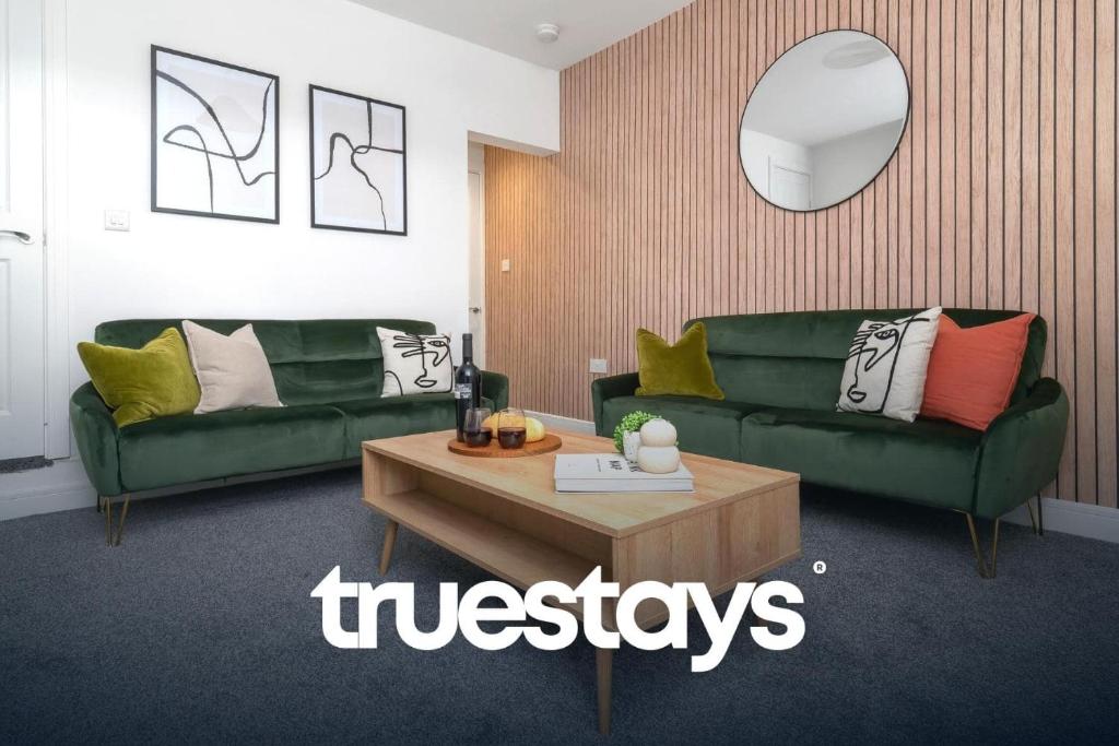 a living room with two green couches and a table at Campbell House by Truestays - NEW 2 Bedroom House in Stoke-on-Trent in Trent Vale