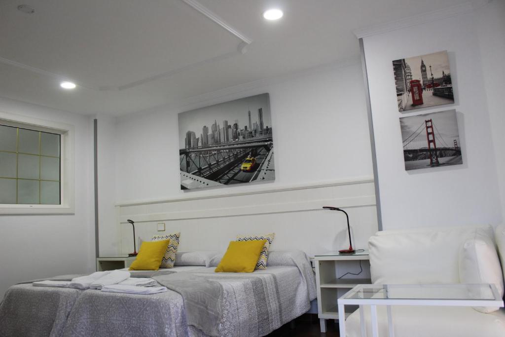ein weißes Zimmer mit 2 Betten und einem Stuhl in der Unterkunft Apartamento Boutique Cruce de Melenara in Melenara
