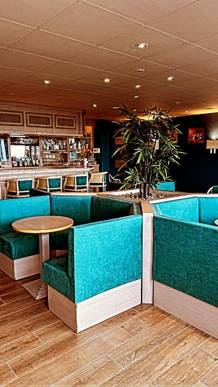 a restaurant with blue chairs and a table and a bar at Hotel de l&#39;Europe in Dieppe