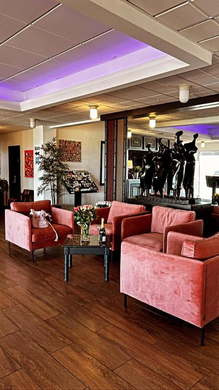 a lobby with red couches and a table with flowers at Hotel de l&#39;Europe in Dieppe
