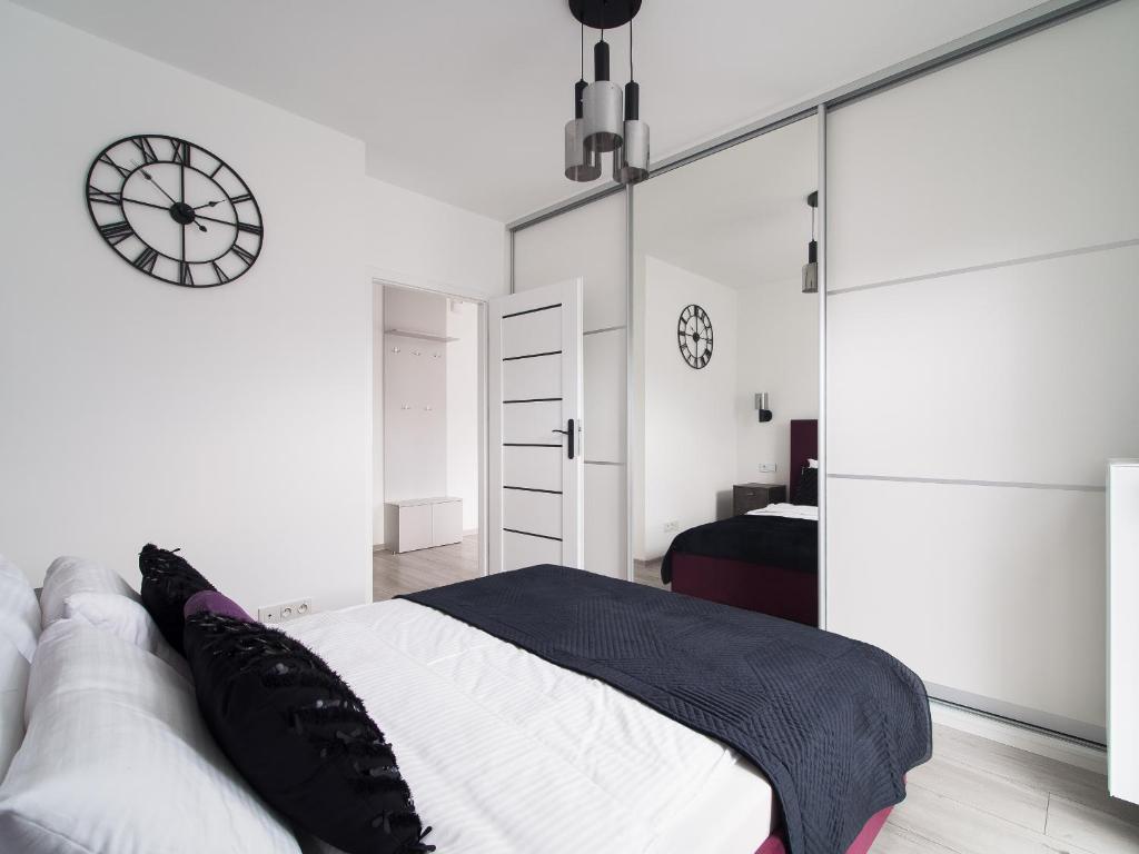 een slaapkamer met een bed en een klok aan de muur bij Szwedzka 22C Perfect Apart in Warschau