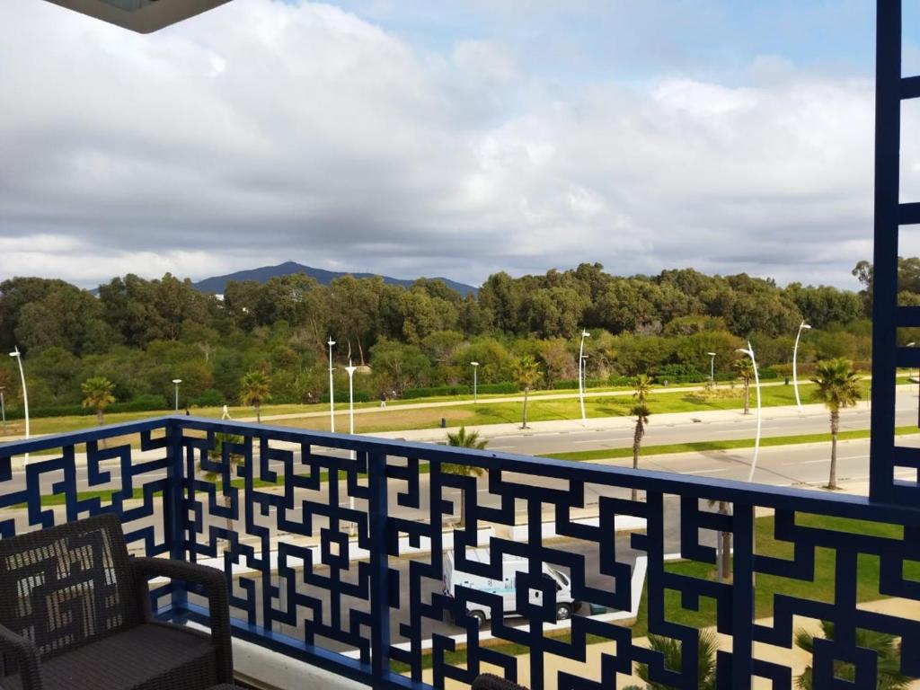 d'un balcon avec un banc et une vue sur un parc. dans l'établissement COSTA MAR MARTIL TETOUAN, à Martil