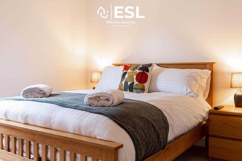 a bedroom with a bed with two towels on it at 2 Bedroom Terrace Cottage, Parking, 5 minutes drive to Royal Shrewsbury Hospital in Shrewsbury