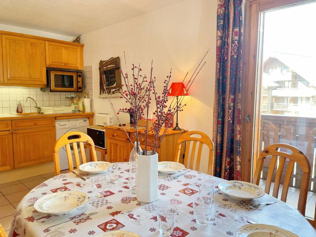 une cuisine avec une table avec un vase de fleurs dessus dans l'établissement Appartement T2 au centre de Samoëns avec balcon, parking et accès navette ski. - FR-1-624-20, à Samoëns