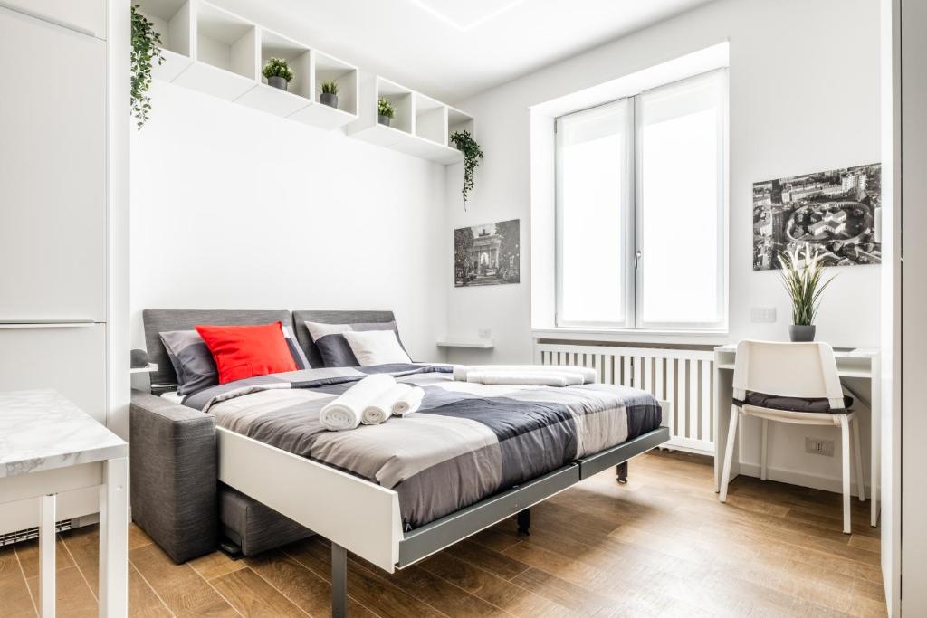 a white bedroom with a bed with red pillows at City Life House-RED Free Parking San Siro & Duomo in Milan