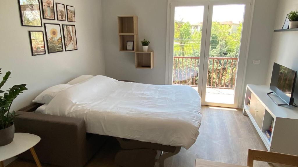 ein Schlafzimmer mit einem weißen Bett und einem Fenster in der Unterkunft Il Girasole in Peschiera del Garda