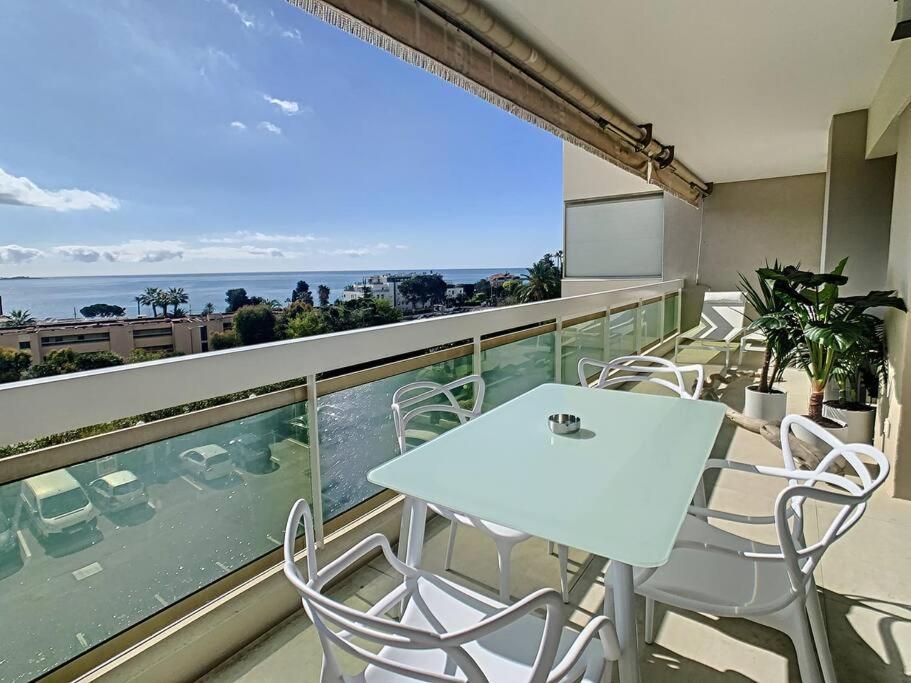einen Balkon mit Stühlen, einem Tisch und Meerblick in der Unterkunft Magnifique appartement vue mer in Vallauris