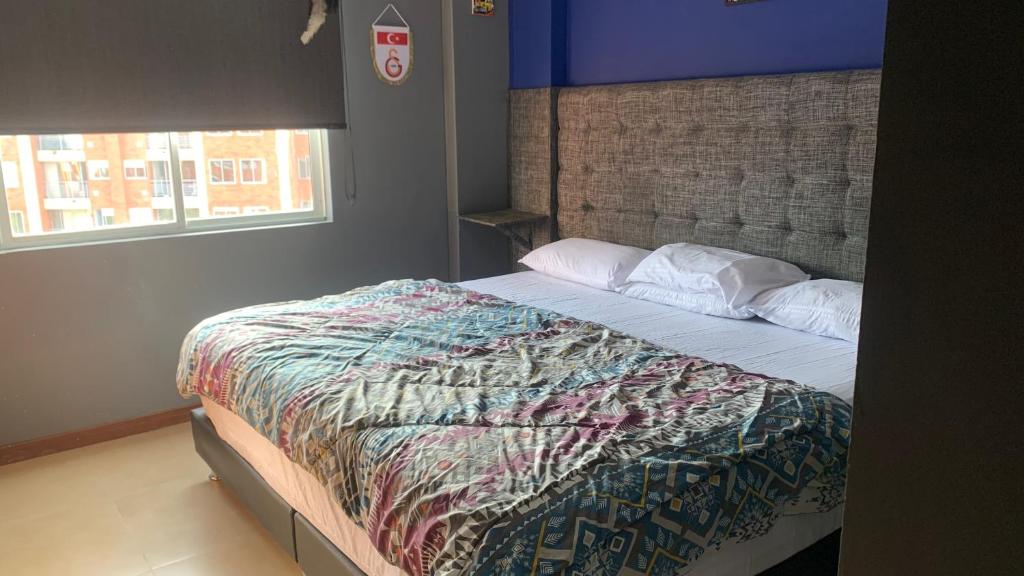 ein Schlafzimmer mit einem Bett mit einer Decke darauf in der Unterkunft Apartamento amoblado nuevo in Pereira