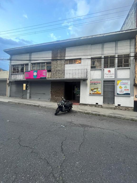 una motocicleta estacionada en la calle frente a un edificio en Departamento en centro de Quito. H&O, en Quito