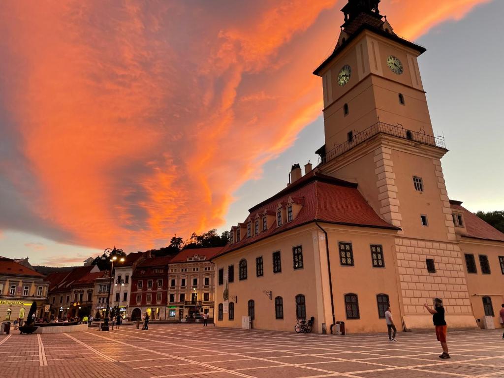 a building with a tower with a clock on it at Key Apartments in Main Square in Braşov