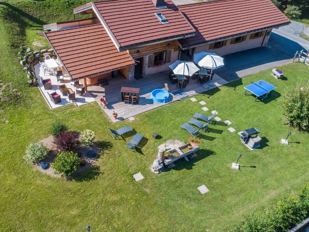 una vista aerea di una casa con cortile attrezzato con tavoli e sedie di Anna - Chalet - BO Immobilier- Châtel -remises sur les forfaits de skis Châtel ou Portes du soleil a Châtel