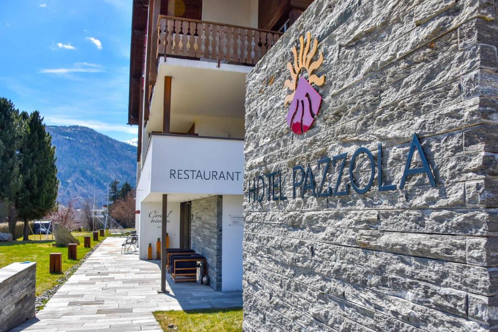 Un edificio con un cartel al costado. en Hotel Pazzola, en Disentis