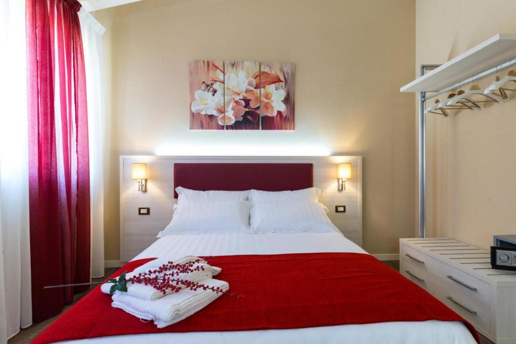 a bedroom with a red and white bed with two towels at Venice Airport Villa Erica 1 in Campalto