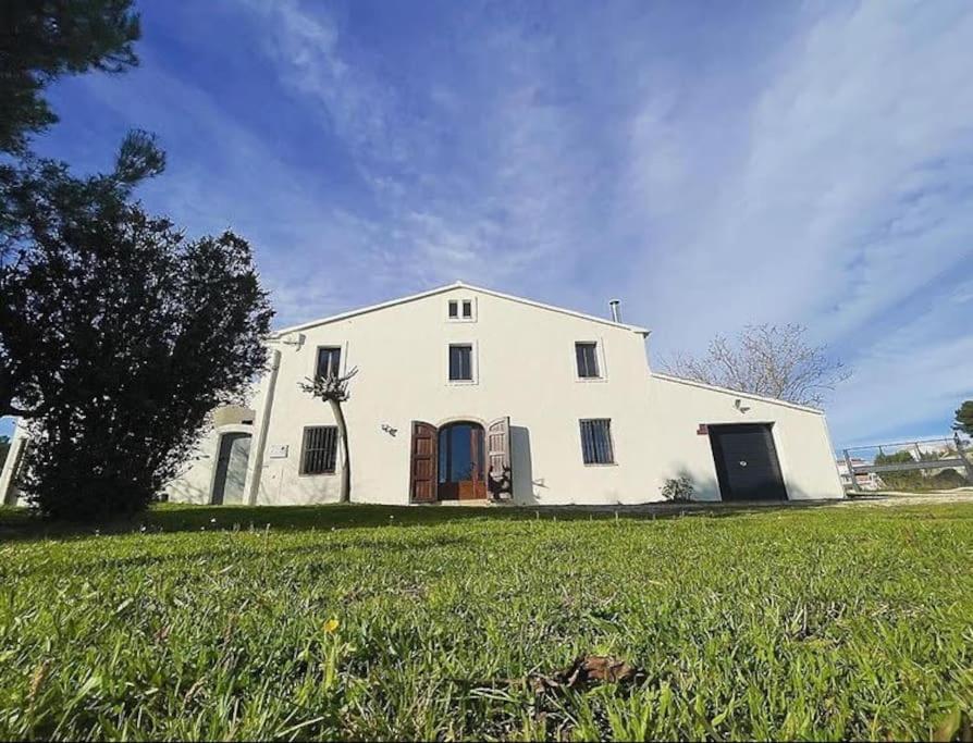 ein großes weißes Haus mit einem großen Grasfeld in der Unterkunft Casa Rural Cal Casetó in Font-Rubí
