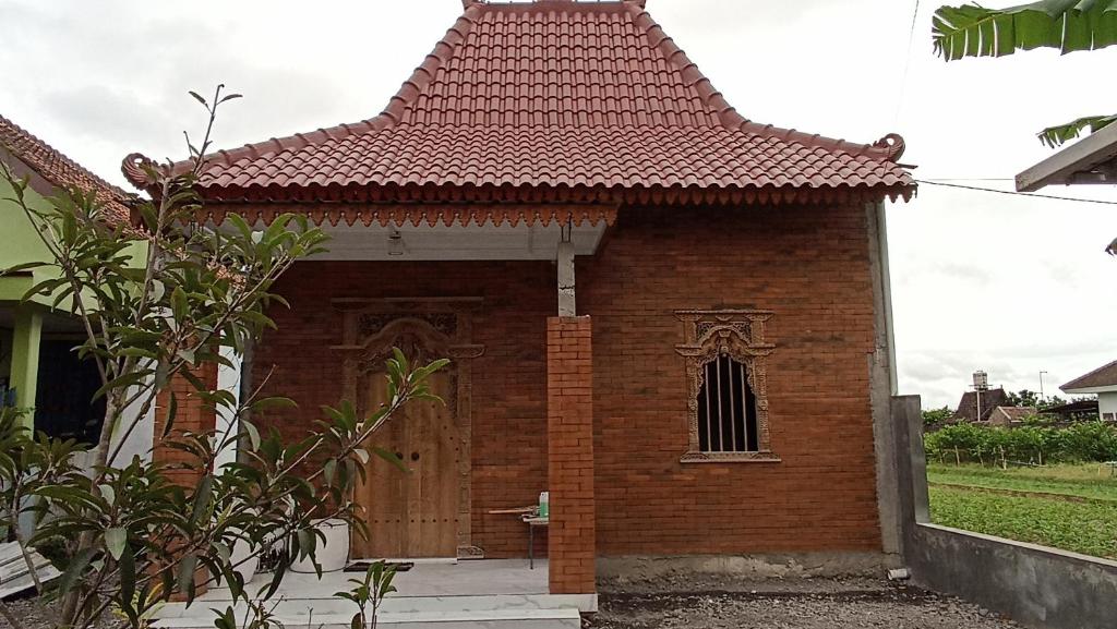 une petite maison en briques avec une porte en bois dans l'établissement Hexa Jongkangan, à Bugisan