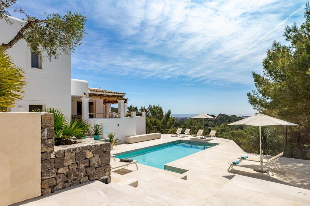 a villa with a swimming pool and a house at Villa Casiopea in Ibiza Town