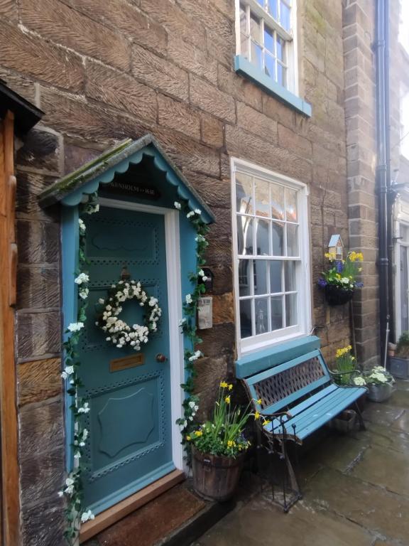 a green door and a bench in front of a house at Darnholm Cottage in Robin Hood's Bay