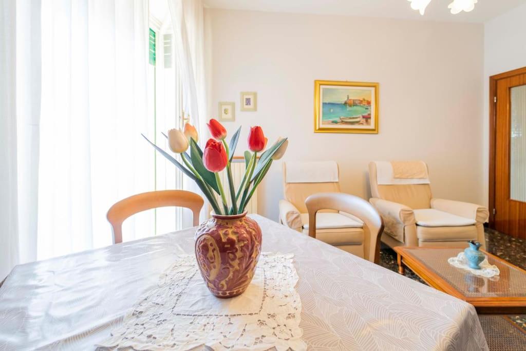 um vaso de tulipas vermelhas sentado numa mesa em 104 - Casa Tulipano Riva Trigoso, a due passi dal mare - Posto auto privato gratis em Riva Trigoso