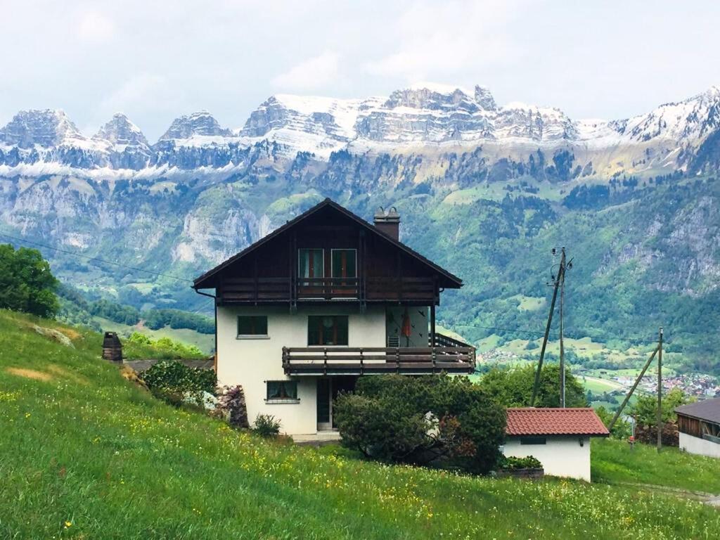 een huis op een heuvel met bergen op de achtergrond bij Wohnung in Bergchalet in Flums