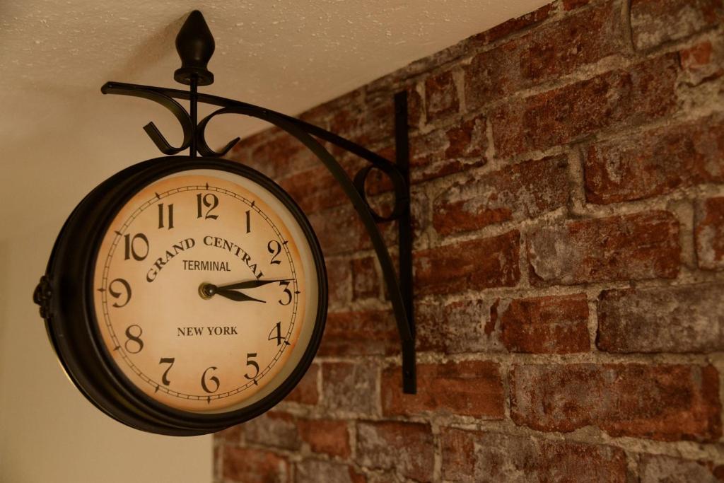 um relógio pendurado numa parede de tijolos em Vintagetraum em Gevelsberg