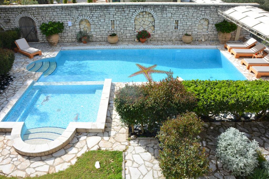 - une piscine avec des chaises et un palmier dans la cour dans l'établissement Villa Alkmini, à Agnítsini