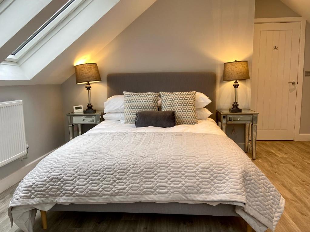 a bedroom with a large white bed with two night stands at Luxury 2 bed home in Stagsden