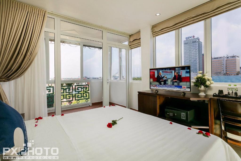 una habitación con una gran mesa blanca con rosas. en Hanoi Stella Hotel en Hanói