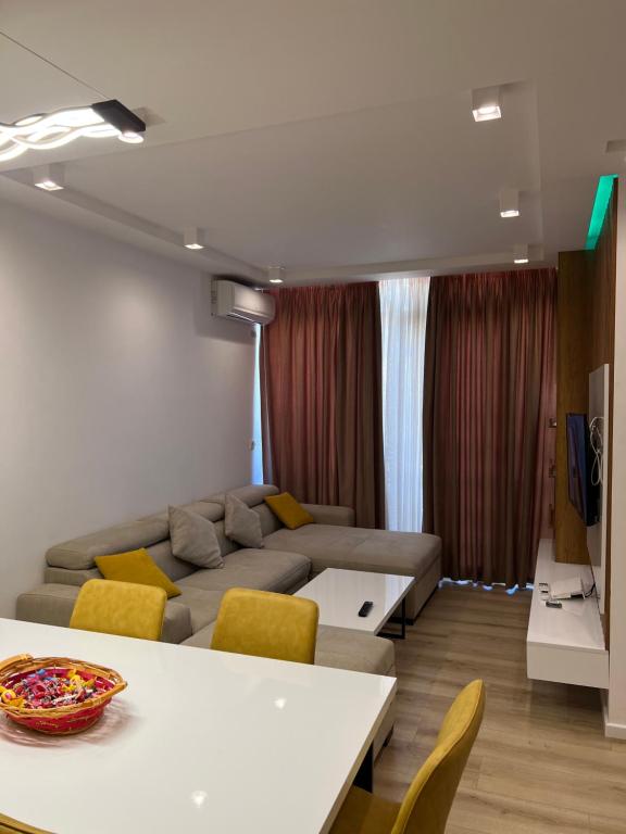- un salon avec un canapé, une table et des chaises dans l'établissement Beach apartment, à Durrës