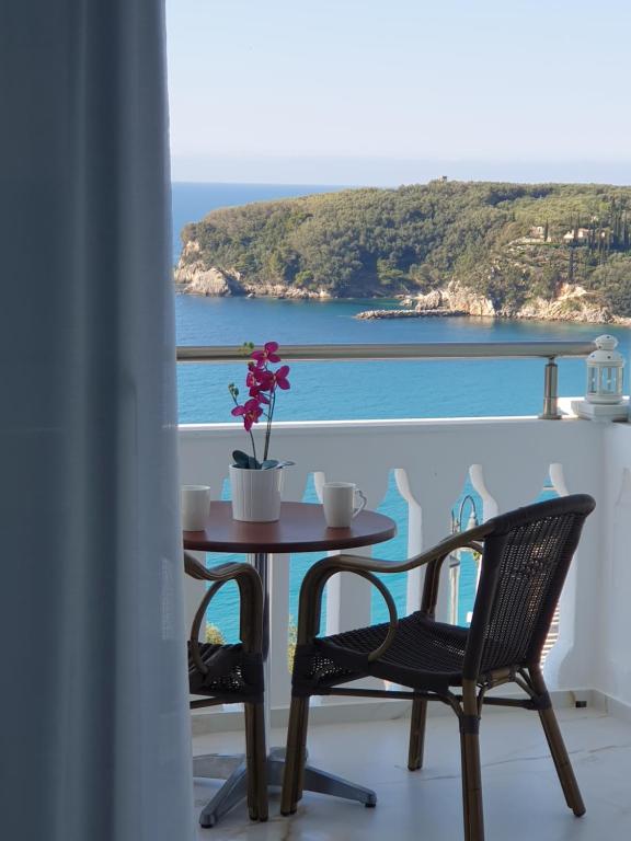 einen Tisch und Stühle auf einem Balkon mit Meerblick in der Unterkunft Andreas Kanali in Parga