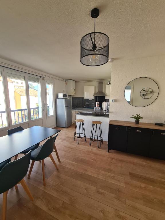 a kitchen with a table and chairs in a room at T2 rénové avec parking gratuit sur place in Valence