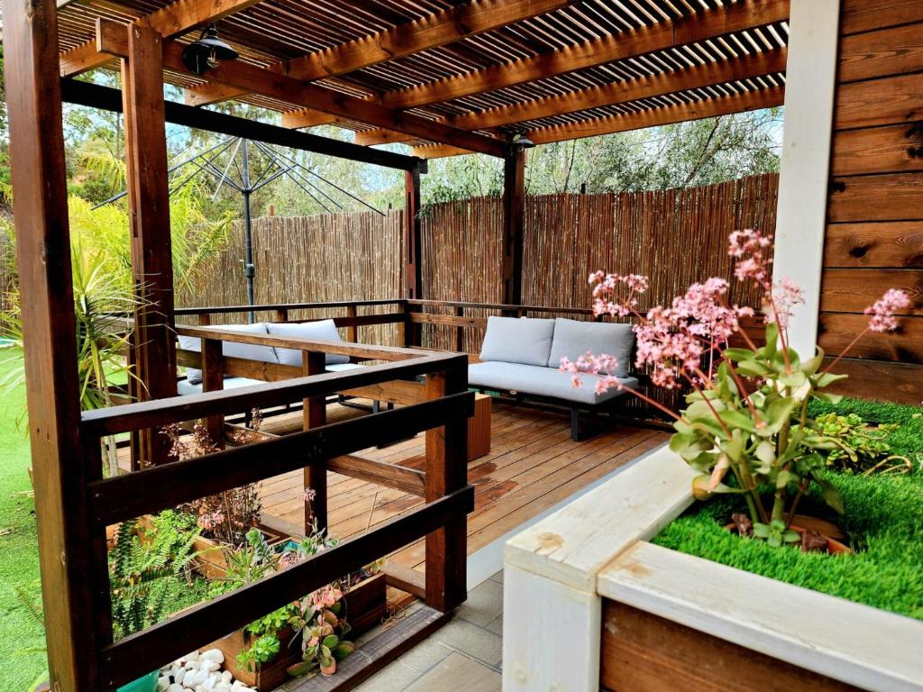 a wooden deck with a pergola and a bench at Extreme Sports Arad in Arad