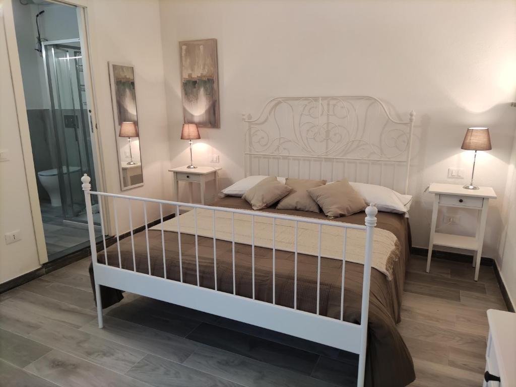 una camera da letto con un letto bianco con due tavoli e due lampade di Affittacamere Ca der Culunellu a Soviore