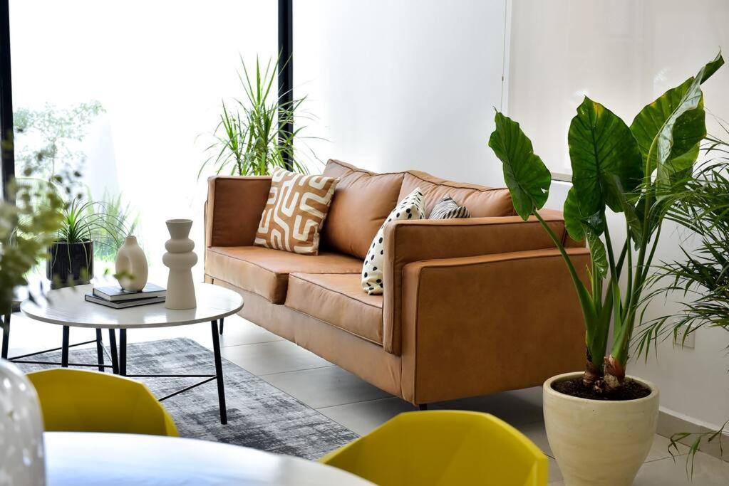 a living room with a couch and a table with plants at Bonita Casa, Cerca de la FNSM, Ideal para grupos in Aguascalientes