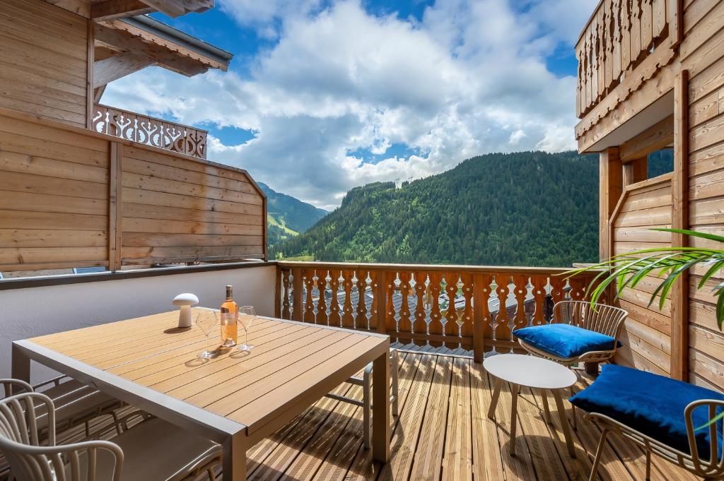 een houten terras met een tafel en stoelen op een balkon bij Perle De Savoie - Apt B303 - BO Immobilier in Châtel