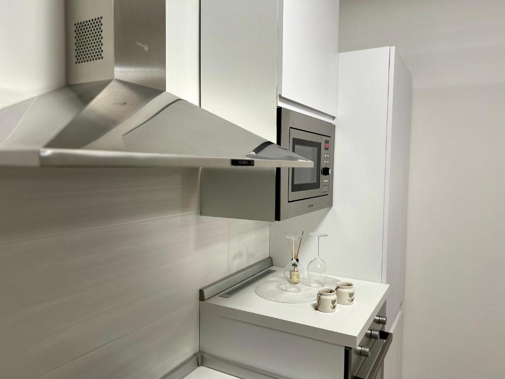 a kitchen with a stainless steel hood and a sink at NEWHOUSE ROOFTOP in Nettuno