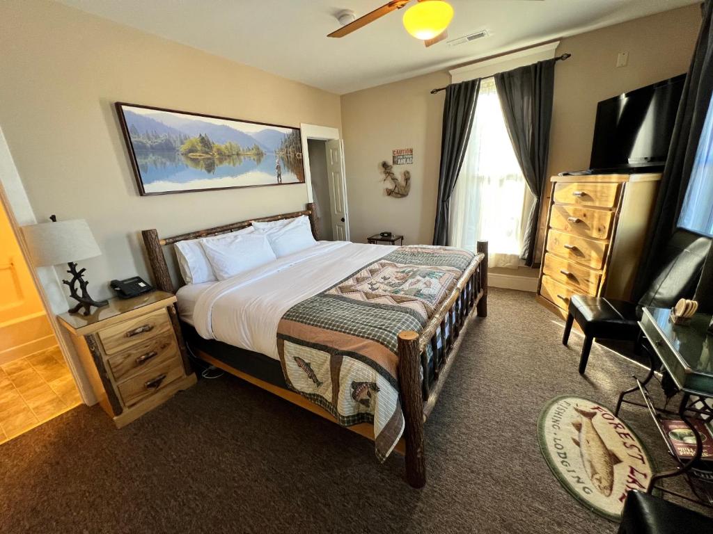 Habitación de hotel con cama y TV en Historic Branson Hotel - Fisherman's Cove Room with King Bed - Downtown - FREE TICKETS INCLUDED, en Branson