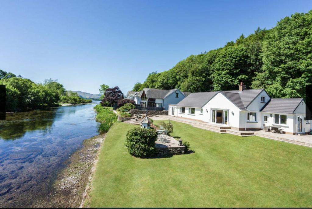 ein Haus am Ufer eines Flusses in der Unterkunft Roxby, Pooley Bridge in Pooley Bridge