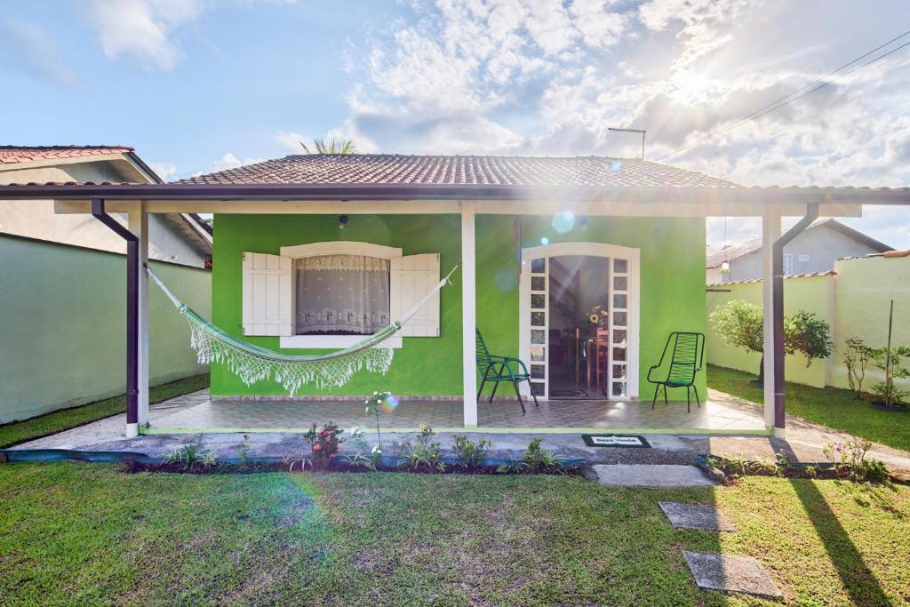 una casa verde con una hamaca en el patio en Casa Magnólia, en Paraty