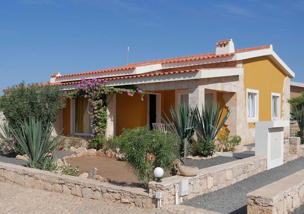 a small yellow house with plants in front of it at Villa Atum. Stella Maris Exclusive in Vila do Maio